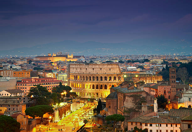 Colosseum in Rome after sunse with citylights stock photo