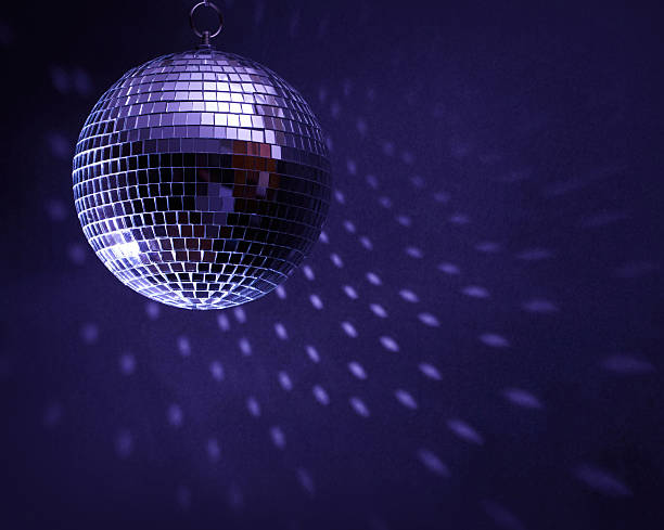 Disco ball in a dark room creating spots on the wall stock photo