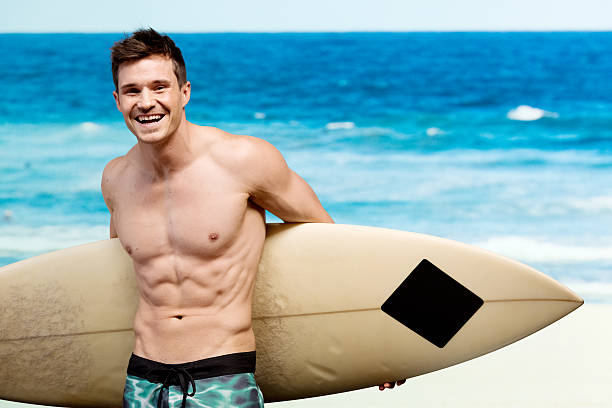 istock Cheerful male surfer holding surfboard at the beach 473318264
