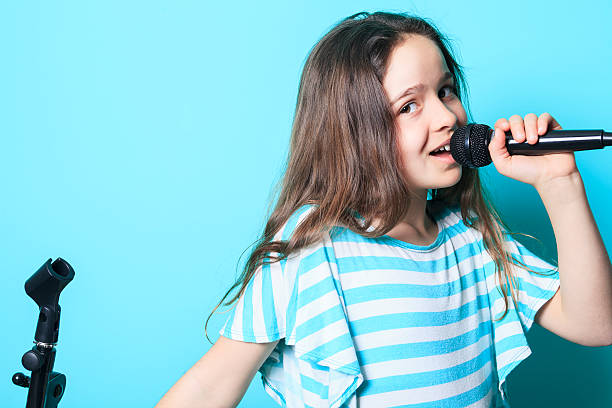 istock girl sing in a microphone 473319168