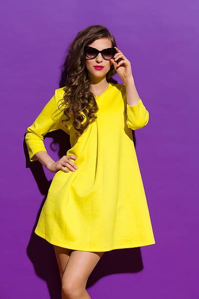 istock Yellow Dress on a Violet Background 473319370