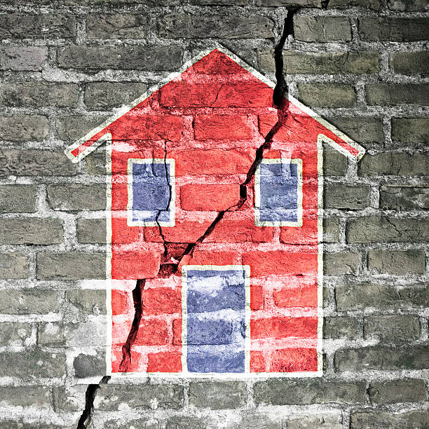 Cracked brick wall with a red house drawn on it Cracked brick wall with a red house drawn on it -concept image crevice photos stock pictures, royalty-free photos & images