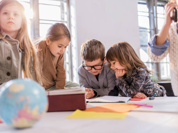 istock Team of creative children reading documents together. 473320374