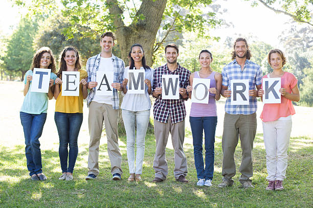 istock Friends holding teamwork signs in the park 473323350