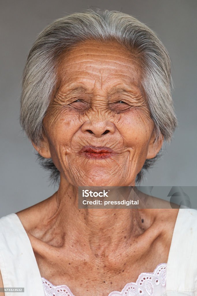 Elderly Asian woman smiling with her eyes closed Portrait old asian woman, close up of wrinkled face 2015 Stock Photo