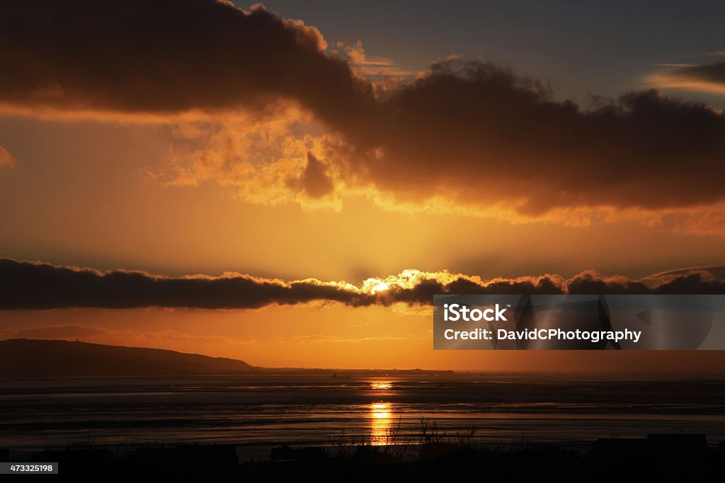 River Dee Sunset A different Sunset view as a thin bank of cloud hides the setting sun over the River Dee and the North Wales coastling 2015 Stock Photo