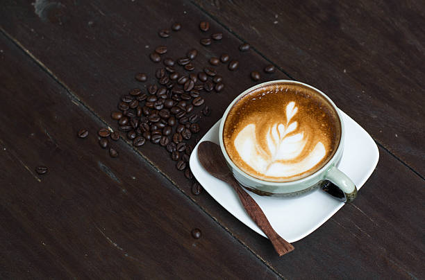 istock Cup of hot latte art coffee on wooden table 473325728