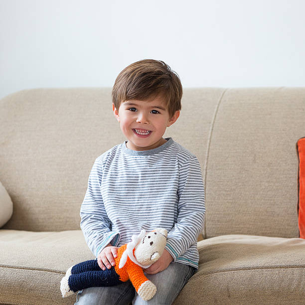istock Portrait of Little Boy Sitting on Sofa 473326226