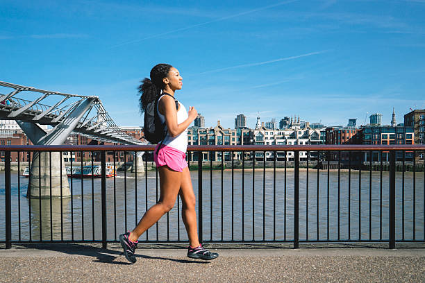 belle femme jogging dans la rue - marathon running london england competition photos et images de collection