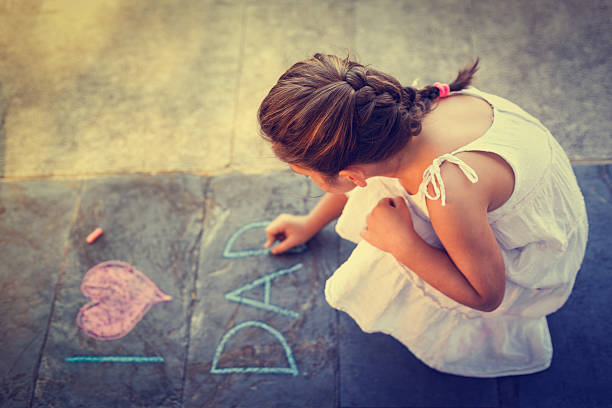 istock Overhead view of girl writing on the sidewalk 473329604
