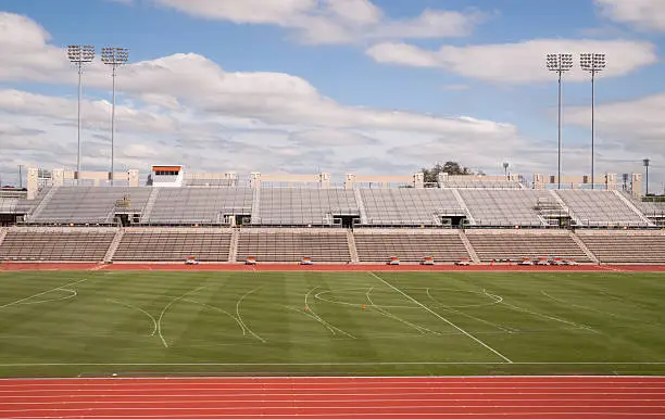 Photo of College Level Track Stadium Puffy Clouds Blue Sky