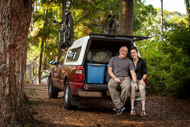 istock Couple sitting on the tailgate before they unload their camp 473330168
