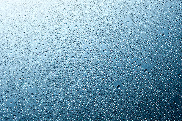 istock Water droplets on glass - Raindrops Rain Window Blue Macro 473330588