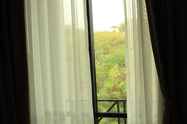 istock open curtain of bedroom window 473333788