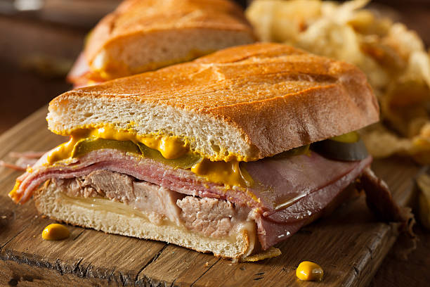 Close-up of a homemade Cuban sandwich on a wooden board Homemade Traditional Cuban Sandwiches with Ham Pork and Cheese cuban culture photos stock pictures, royalty-free photos & images