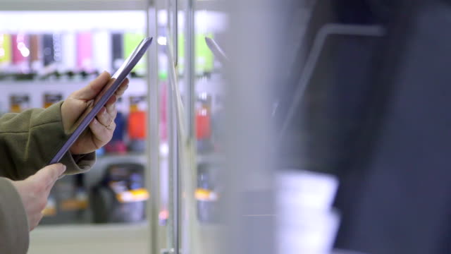 Customer buying digital tablet in electronics store