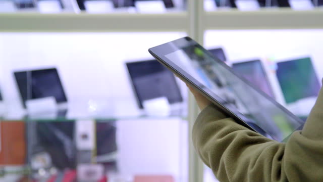 DOLLY: Customer testing new digital tablet at electronics store