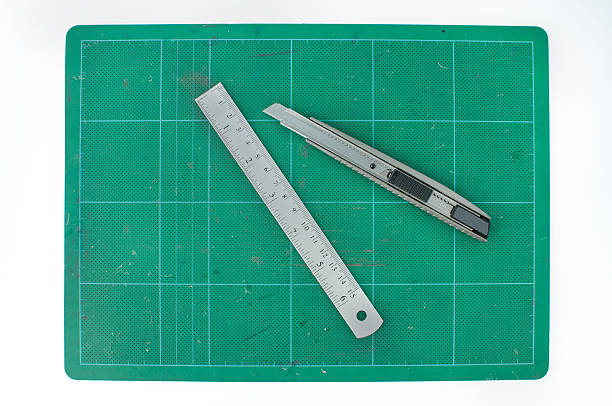 istock Green cutting mats with ruler and cuter on white background 473340040