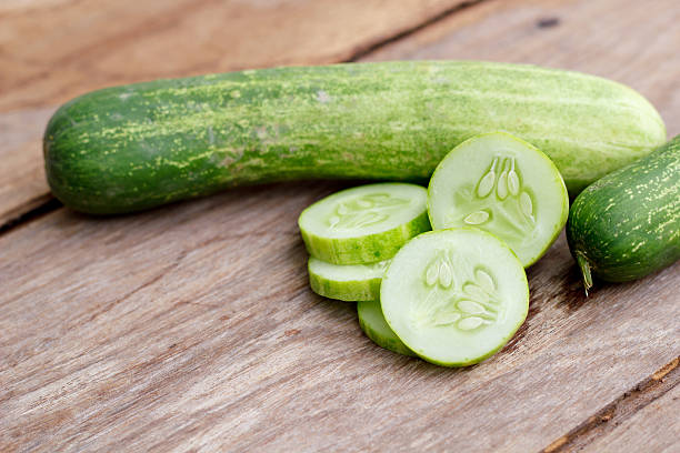 istock Cucumber isolated on wood background. 473342422