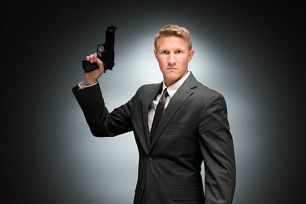 istock Angry businessman holding handgun 473342876
