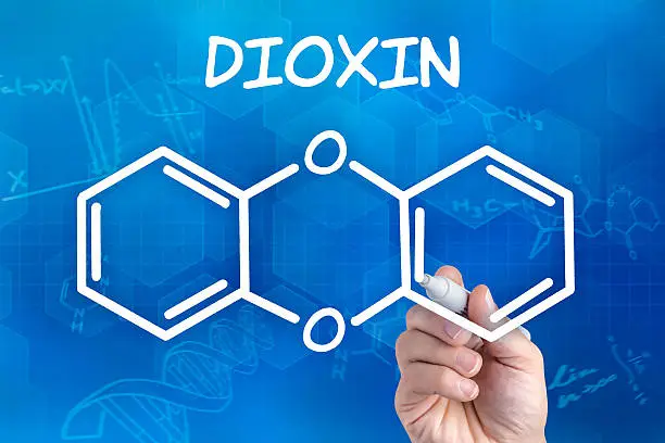 Photo of hand with pen drawing the chemical formula of dioxin