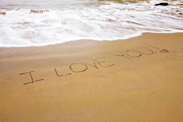istock I love you written on a sandy beach 473347834