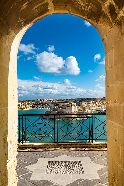 Harbor in Vallettain frame Night view of a harbor in Valletta, Malta view from an arcade frame valletta photos stock pictures, royalty-free photos & images
