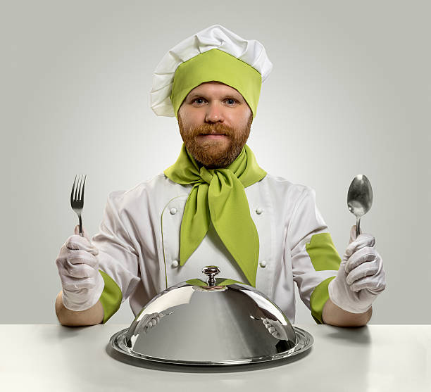 istock cook chef with fork, spoon and food tray 473350766