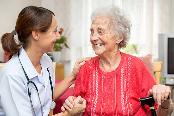 istock Senior woman and nurse holding hands 473356490