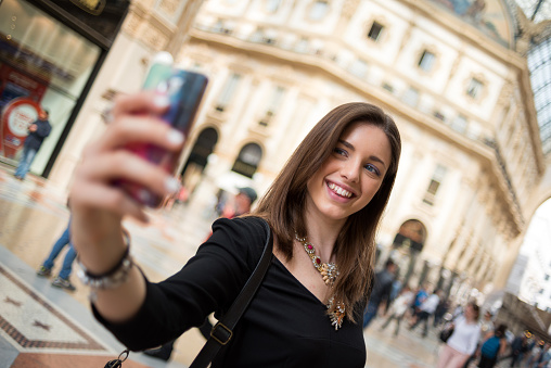 Young beautiful woman taking selfie in Galleria Vittorio Emanuele, Milan