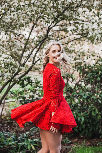 istock Beautiful young woman outdoors dancing dressed in red 473360052