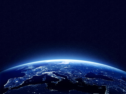 Earth at night as seen from space with blue, glowing atmosphere and space at the top. Perfect for illustrations.  Elements of this image furnished by NASA