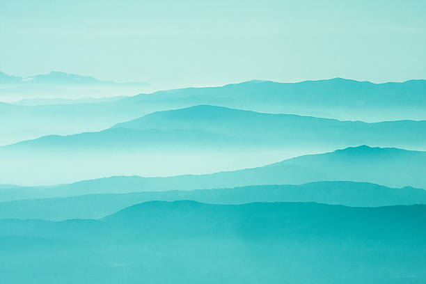 A blue image of a mountains sunrise Scenic Landscape Mountains. Sunrise Layers. grain added mountain layers stock pictures, royalty-free photos & images