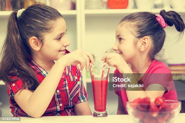 Hermosas Chicas Bebiendo Un Poco Un Batido De Fresa Foto de stock y más banco de imágenes de 10-11 años
