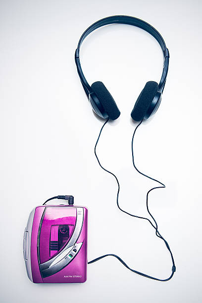 Classic Personal Tape Player and Headphones A bright pink "walkman" personal cassette tape player and ear muff style headphones on a white studio background.  View from directly overhead looking down.  A must have utility of the late 1980's and early 1990's. personal stereo stock pictures, royalty-free photos & images