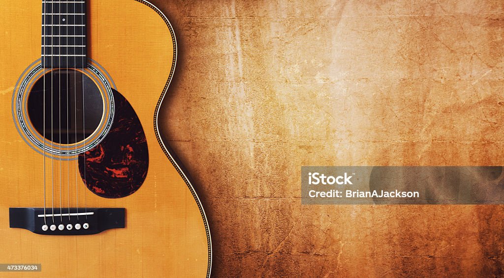 Guitar and blank grunge background Acoustic guitar resting against a blank grunge background with copy space Guitar Stock Photo