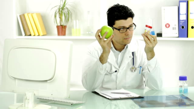 Young Doctor Holding Apple and Pills Fruit Medicine Concept