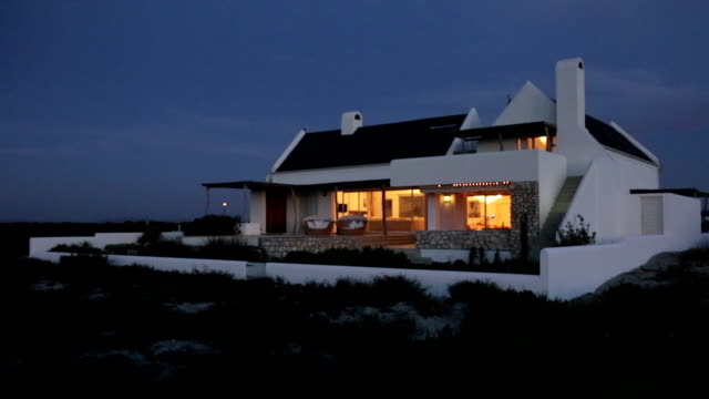 Beach house illuminated at night. MS, real time.