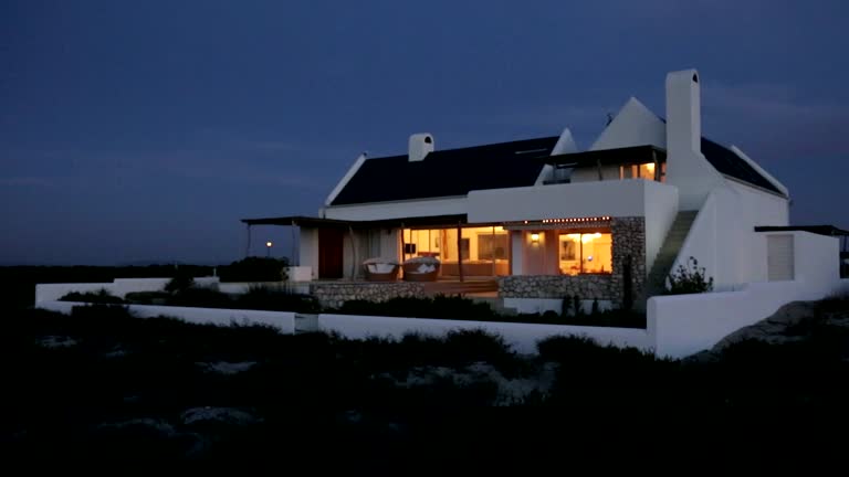 Beach house illuminated at night. MS, real time.