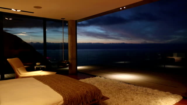 Luxury bedroom overlooking ocean at dusk