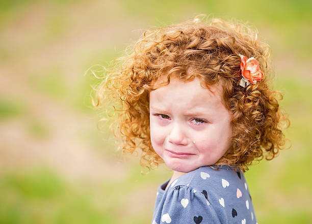 Little Girl With Curly Red Hair Crying stock photo