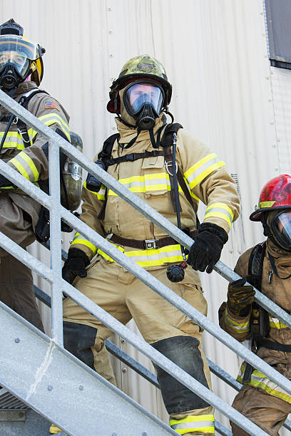 istock Firefighters climbing stairs outside industrial building 473421908