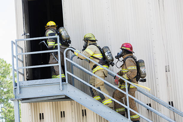 istock Firefighters climbing stairs outside industrial building 473421914