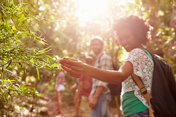 istock Woman looking at leaves during hike with friends 473422158
