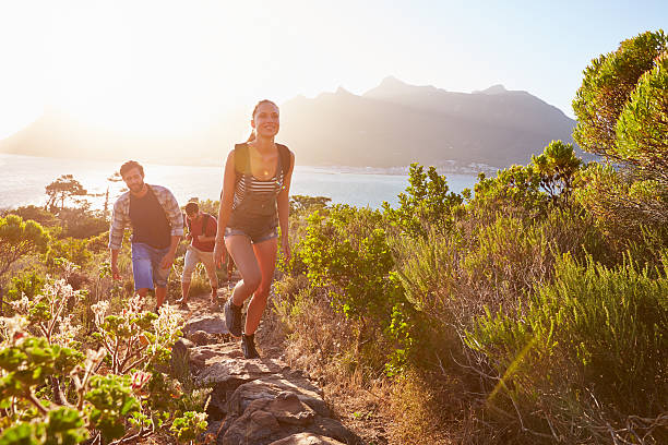istock Group Of Friends Walking Along Coastal Path Together 473422502