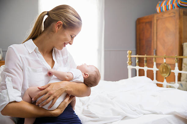 istock Mother Dressed For Work Holding Baby In Bedroom 473424488