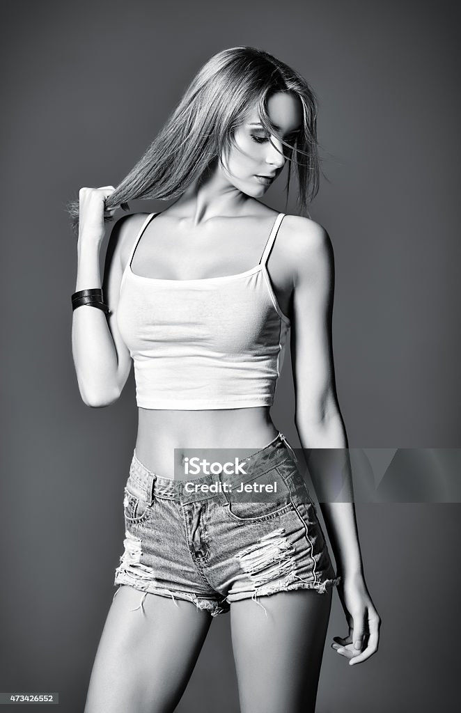 Fashion shot: beautiful girl in denim shorts and shirt Fashion shot: a beautiful girl in denim shorts and shirt. Black and white 2015 Stock Photo