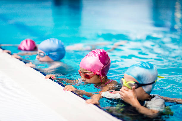 Group of children on swimming class Group of children on swimming class, making bubbles swimming cap stock pictures, royalty-free photos & images