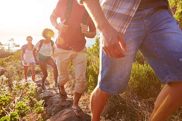 istock Group Of Friends Walking Along Coastal Path Together 473428760