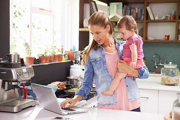 istock Mother with her baby using a laptop in the kitchen 473429794